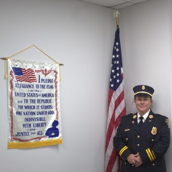 Jessica Shappelle in uniform next to flag and pledge banner